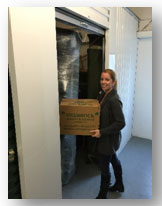A customer carrying a box into her storage unit